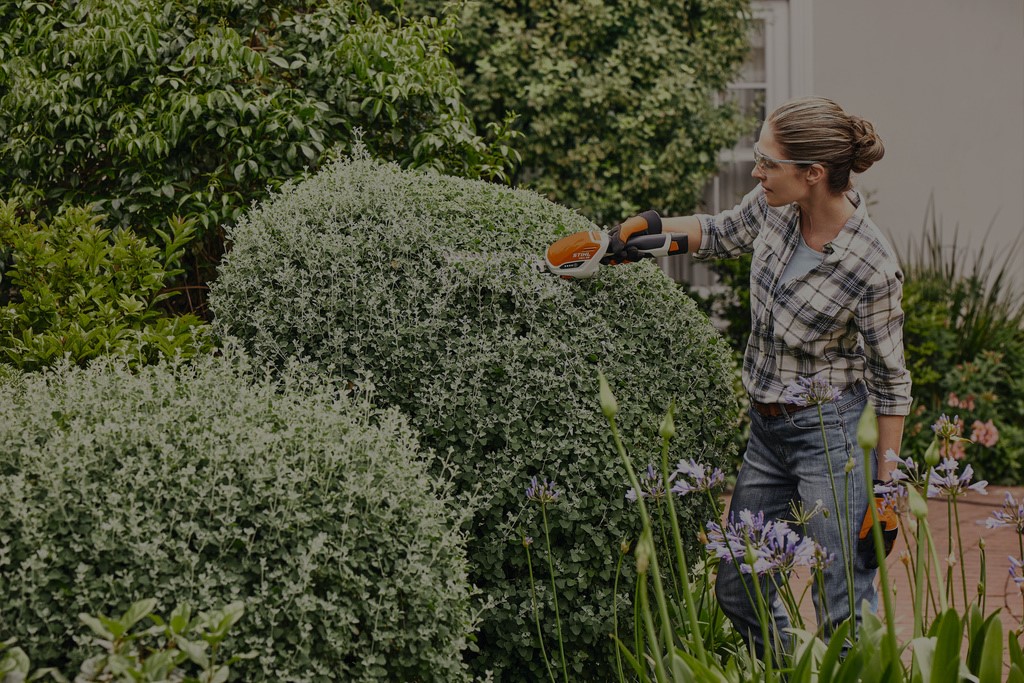 Loja STIHL com produtos da loja da marca e uma mulher segura na camisola STIHL